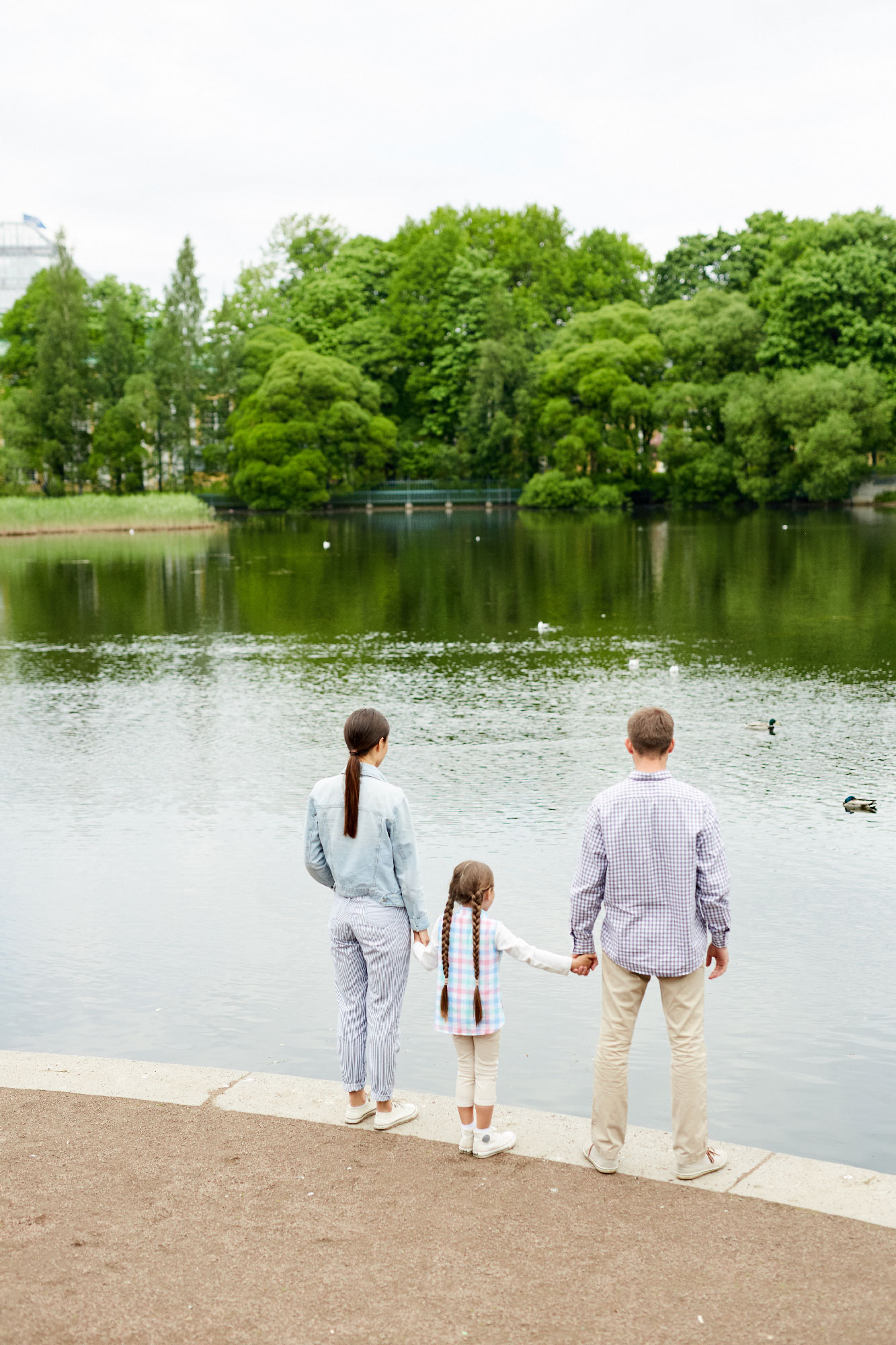 Une famille se tient la main devant une étendue d'eau
